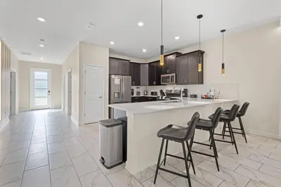 a kitchen with a counter and bar stools at 4561 Majestic 9BD Kingdom Retreat Near Disney in Kissimmee