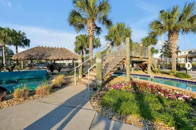 a resort with a staircase and a swimming pool with palm trees at Storey Lake Home: Pool, Gym, Lazy River & near Disney in Kissimmee