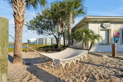 a hammock on the beach next to a building at Storey Lake Home: Pool, Gym, Lazy River & near Disney in Kissimmee