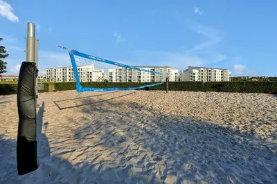 a volleyball net on the beach with buildings in the background at Storey Lake Home: Pool, Gym, Lazy River & near Disney in Kissimmee