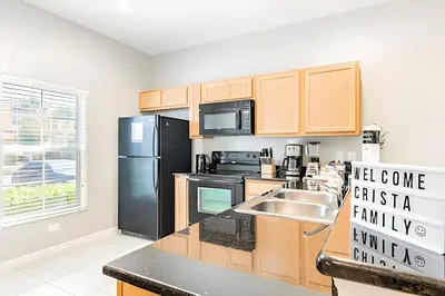 a kitchen with a black refrigerator and a sink at 3Q/2.5B ✰ Jacuzzi ✰ Cama King in Kissimmee