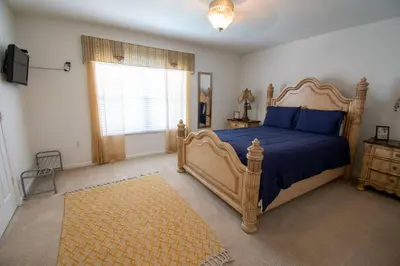a bedroom with a bed with blue sheets and a window at Stunning 6 bedroom vacation villa in Orlando