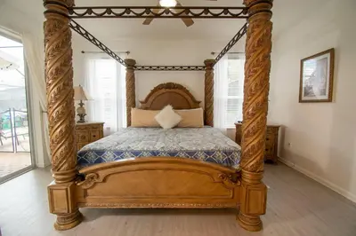 an ornate wooden canopy bed in a bedroom at Stunning 6 bedroom vacation villa in Orlando