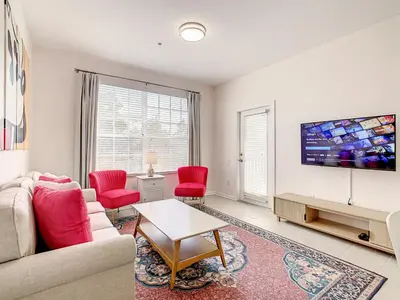 a living room with a couch and red chairs at Windsor Hills Luxury Condo, Pool,Slides, By Disney in Orlando