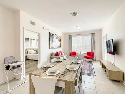 a dining room with a table and chairs in a living room at Windsor Hills Luxury Condo, Pool,Slides, By Disney in Orlando