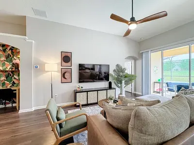 a living room with a couch and a ceiling fan at Windsor Palms Minion, Princess, Mickey, Pool Home in Kissimmee