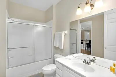 a bathroom with a sink and a toilet and a mirror at Updated 3BR Condo near Convention Center & Epic in Orlando