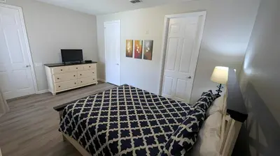 a bedroom with a bed and a dresser and a television at Updated 3BR Condo near Convention Center & Epic in Orlando