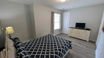 a bedroom with a bed and a dresser and a window at Updated 3BR Condo near Convention Center & Epic in Orlando