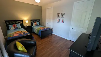 a living room with two beds and a chair at 2BR Condo close Convention Center l Epic in Orlando