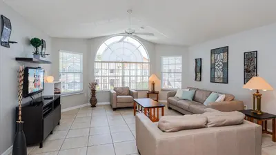 a living room with a couch and a tv at Villas At Island Club Community, Pools, Jacuzzi And More! in Kissimmee