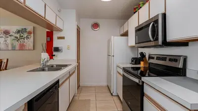 a small kitchen with a sink and a refrigerator at Villas At Island Club Community, Pools, Jacuzzi And More! in Kissimmee