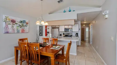 a kitchen and dining room with a table and chairs at Villas At Island Club Community, Pools, Jacuzzi And More! in Kissimmee