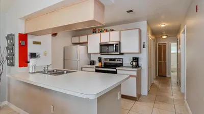 a kitchen with white cabinets and a white counter top at Villas At Island Club Community, Pools, Jacuzzi And More! in Kissimmee
