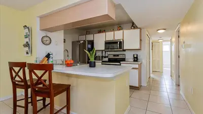 a kitchen with white cabinets and a counter top at Villas At Island Club Community, Pools, Jacuzzi And More! in Kissimmee
