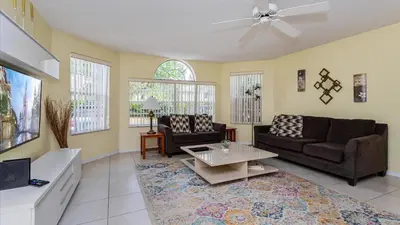 a living room with two couches and a table at Villas At Island Club Community, Pools, Jacuzzi And More! in Kissimmee