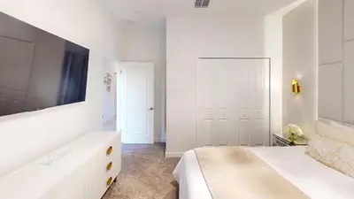 a white bedroom with a bed and a tv at Storey Lake Resort 1119 - Hosted by Top Villas in Kissimmee