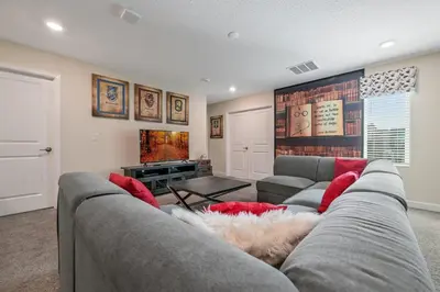 a living room with a gray couch and red pillows at Storey Lake Resort 1136 - Hosted by Top Villas in Kissimmee