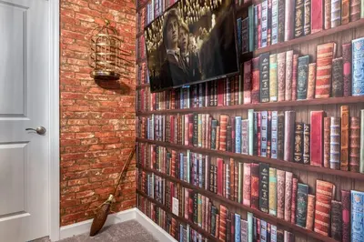 a book shelf filled with books next to a brick wall at Formosa Valley Resort 63 - Hosted by Top Villas in Orlando