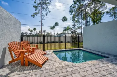 a patio with two chairs and a swimming pool at Formosa Valley Resort 64 - Hosted by Top Villas in Orlando