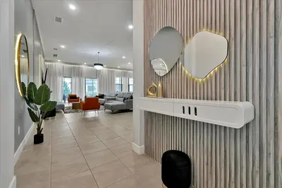 a living room with two mirrors on a wall at Epic Orlando Mansion-Pool-Game Room-Theater-2 in Orlando