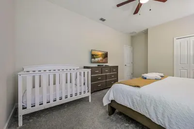 a bedroom with a crib and a dresser at Storey Lake Resort 1120 - Hosted by Top Villas in Kissimmee