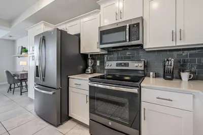 a kitchen with stainless steel appliances and white cabinets at Storey Lake Resort 1059 - Hosted by Top Villas in Kissimmee