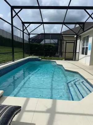 a large swimming pool with a metal roof at Magical Home with private pool and close to parks in Kissimmee