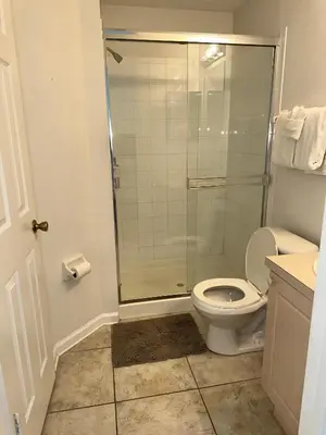 a bathroom with a toilet and a glass shower at Magical Home with private pool and close to parks in Kissimmee