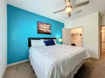 a bedroom with a blue wall and a large bed at Luxury Apartments Near Disney in Orlando
