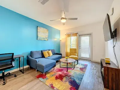 a living room with a blue couch and a piano at Luxury Apartments Near Disney in Orlando