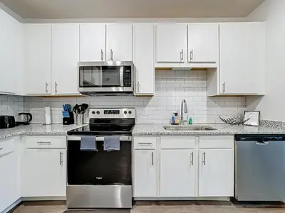 a kitchen with white cabinets and a black appliance at Luxury Apartments Near Disney in Orlando