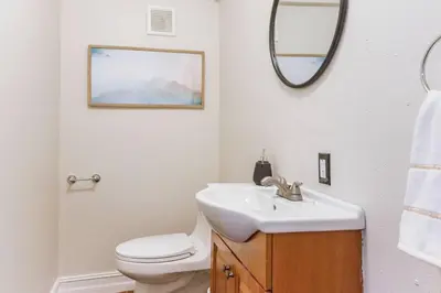 a bathroom with a sink and a toilet and a mirror at Private Oasis near Springs with King Bd and Pool Table in Orlando