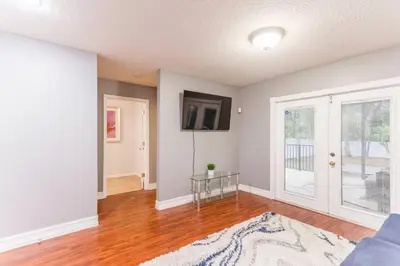 a living room with a couch and a tv on a wall at Private Oasis near Springs with King Bd and Pool Table in Orlando