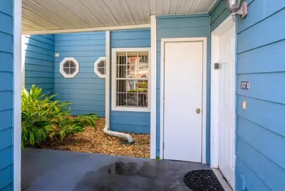 a blue house with a white door at Villas At Island Club Community, Pools, Jacuzzi And More! in Kissimmee