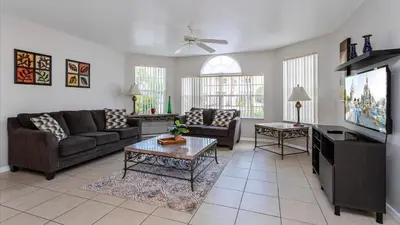 a living room with a couch and a tv at Villas At Island Club Community, Pools, Jacuzzi And More! in Kissimmee