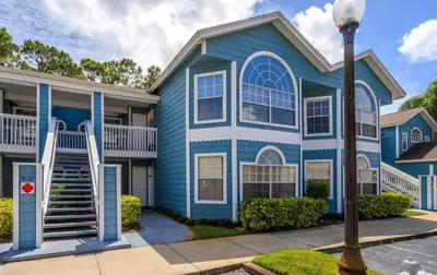a blue house with a street light in front of it at Villas At Island Club Community, Pools, Jacuzzi And More! in Kissimmee