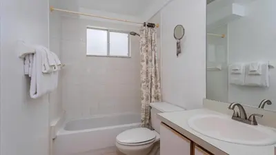 a white bathroom with a sink and a toilet at Villas At Island Club Community, Pools, Jacuzzi And More! in Kissimmee