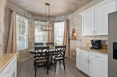 a kitchen with a dining room table and chairs at Free Arcade! All Rooms Themed! South Facing Pool! in Orlando