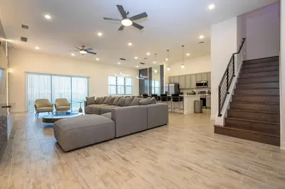 a large living room with a couch and a ceiling fan at BRAND NEW 15Bed Home wprivate Pool 5824 in Orlando