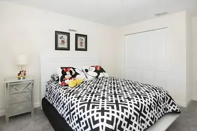 a bedroom with a black and white bed with stuffed animals at Waterpark Disney wPoolLakeView Storey Lake in Kissimmee