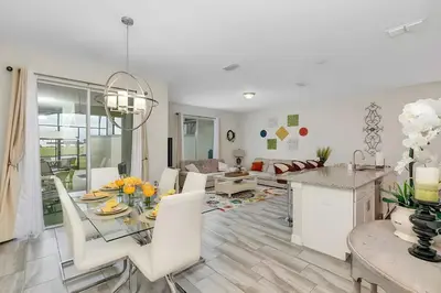 a dining room and living room with a table and chairs at Waterpark Disney wPoolLakeView Storey Lake in Kissimmee