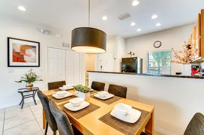 a dining room and kitchen with a table and chairs at 4 Mi to Disney World Townhome with Hot Tub and Lanai! in Kissimmee