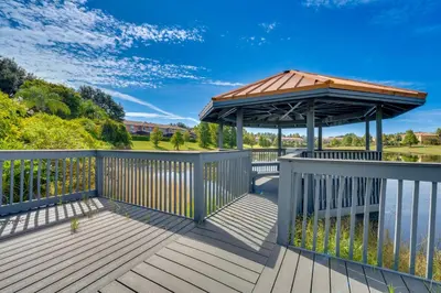 a wooden deck with a gazebo on it at 4 Mi to Disney World Townhome with Hot Tub and Lanai! in Kissimmee