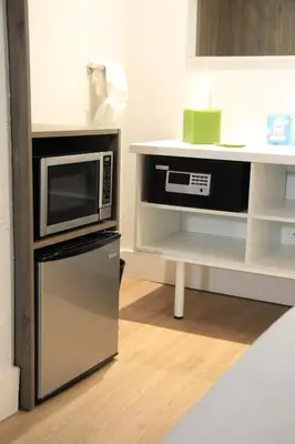 a kitchen with a microwave and a refrigerator at Apartamento Perto Disney in Kissimmee