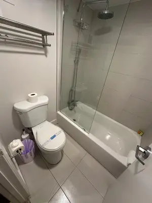 a bathroom with a toilet and a glass shower at Apartamento Perto Disney in Kissimmee