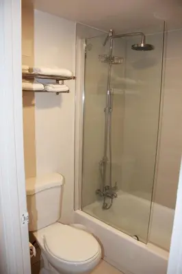 a bathroom with a toilet and a glass shower at Apartamento Perto Disney in Kissimmee