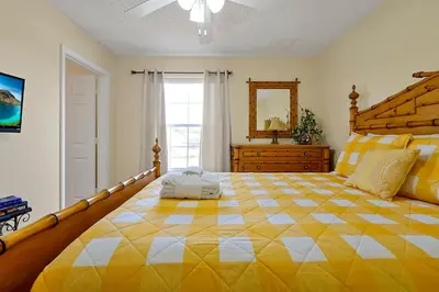 a large bedroom with a large bed with a yellow and white checkered at Lakefront Villa in Terra Verde:Pool & Resort Amenities in Kissimmee