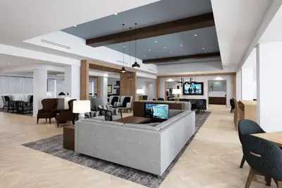 a lobby with a couch and chairs and a television at Staybridge Suites Clermont Southeast by IHG in Clermont