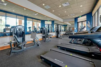 a gym with treadmills and machines in a room at Corvette Getaway - 2 beds - jacuzzi - Forest view in Orlando